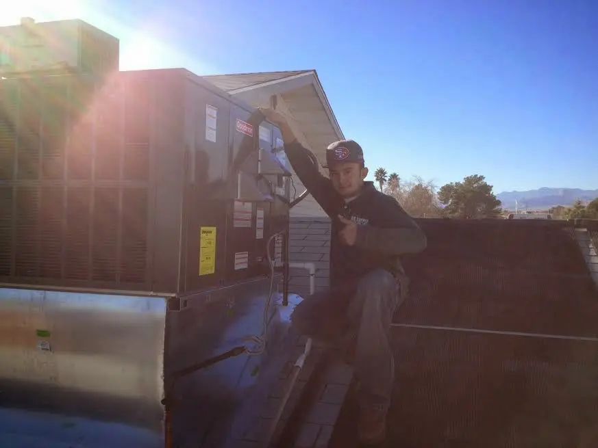HVAC technician performing AC Tune-Up on a rooftop unit in Port Clinton